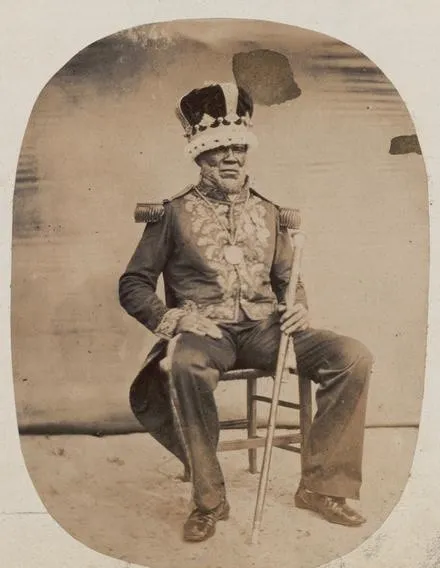 Photographie de 1862 : le roi Denis assis, couronne à plumes, uniforme brodé à épaulettes, sceptre en main